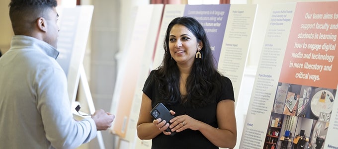 Researcher shares poster on her work with an attendee during the Internal Funding Showcase