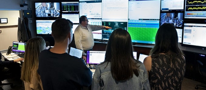 students view wall of data screens during visit to UPMC Data Center