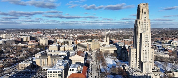 Pittsburgh campus in winter features Cathedral of Learning on sunny day